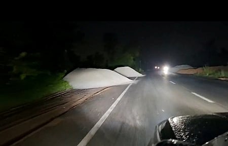 Heaps of fly ash dumped along road.