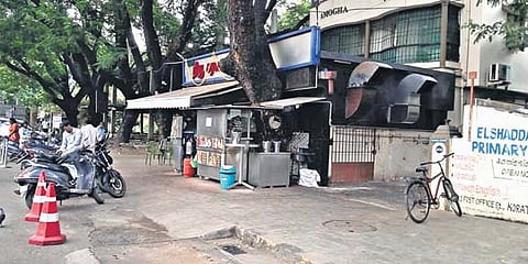 A hotel kitchen partially encroaches on a footpath in Korattur