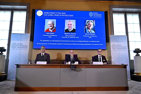 Chair of the Nobel Committee for Chemistry Heiner Linke makes a demonstration, next to Secretary General of the Swedish Academy of Sciences Hans Ellegren, and Member of the Nobel Committee for Chemistry Olof Ramstrom, right, after they announce Susumu Kitagawa, Richard Robson and Omar Yaghi, on screen behind, as the recipients the Nobel Prize in Chemistry, at the Nobel Assembly of the Karolinska Institutet, in Stockholm, Sweden, Wednesday, Oct. 8, 2025.