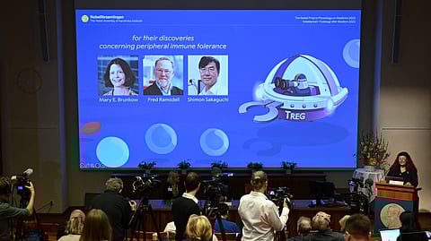 Marie Wahren-Herlenius (R), Professor of Rheumatology at the Karolinska Institutet, stands next to a screen displaying the portraits of (L-R) Mary E Brunkow, Fred Ramsdell and Shimon Sakaguchi as she addresses journalists during a press conference to announce the winners of the 2025 Nobel Prize in Physiology or Medicine at the Karolinska Institute in Stockholm, Sweden, on October 6, 2025. 