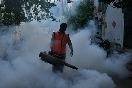 A municipal corporation worker fumigates streets and drains to contain bacteria and mosquito larvae in Vijayawada on Wednesday. 