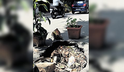 Pots placed around a crater on a road in RMV Extension.