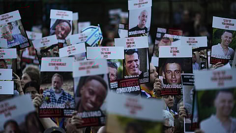 People hold up posters of hostages in Hamas captivity in Gaza, to demand their release, in Buenos Aires, Argentina, Tuesday, Sept. 30, 2025.
