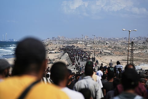 Displaced Palestinians walk along the coastal road near Wadi Gaza in the central Gaza Strip, moving toward northern Gaza, Friday, Oct. 10, 2025, after Israel and Hamas have agreed to a pause in their war and the release of the remaining hostages.
