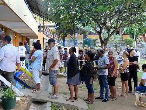 People line up to cast their votes in a runoff presidential election at Mont Fleuri Secondary School, Mont Fleuri, Mahe, Seychelles, Saturday, Oct. 11, 2025.