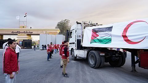 Egyptian Red Crecent members monitor trucks carrying humanitarian aid as they enter the Rafah crossing between Egypt and the Gaza Strip, following an agreement between Israel and Hamas on a ceasefire, Sunday, Oct. 12, 2025.