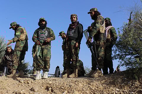 Taliban security personnel on a Soviet-era tank are followed by motorcyclists as they ride towards the border, as clashes take place between Taliban security personnel and Pakistani border forces, in the Spin Boldak district of Kandahar Province on October 15, 2025.