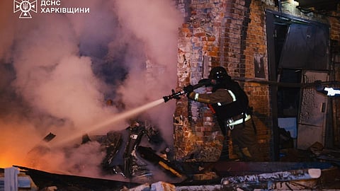 In this photo provided by the Ukrainian Emergency Services on Tuesday, Oct. 14, 2025, a rescue worker puts out a fire of a hospital damaged by a Russian strike in Kharkiv, Ukraine