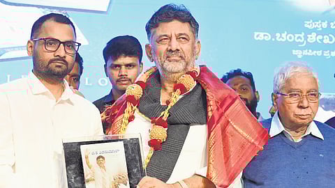 A book titled ‘DK Shivakumar, A Symbol of Loyalty and Troubleshooter’ is released by its author KM Raghu and Deputy CM DK Shivakumar, as Jnanpith awardee Dr Chandrashekar Kambar looks on, in Bengaluru on Wednesday