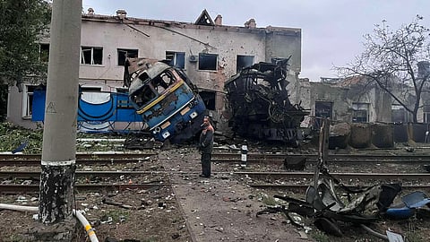In this photo provided by the Office of the Deputy Prime Minister for Restoration and Development on Thursday, Oct. 2, 2025, a railway worker stands in front of a train locomotive destroyed by a Russian strike in Odesa, Ukraine.