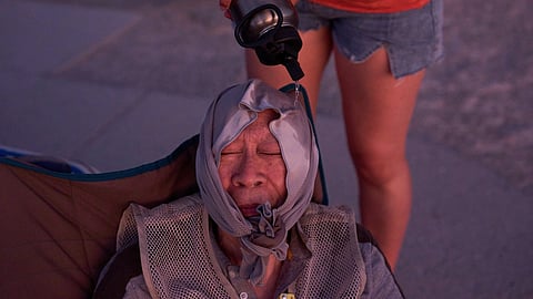 Grace Chyuwei pours water on Joe Chyuwei to help with the heat on Aug. 3, 2025, in Death Valley National Park, Calif.