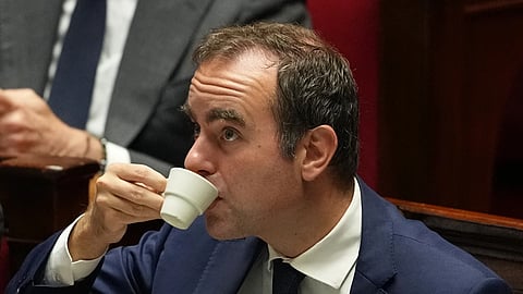 French Prime Minister Sébastien Lecornu drinks as he listens to speeches before a no-confidence vote, Thursday, Oct 16, 2025 at the National Assembly in Paris.