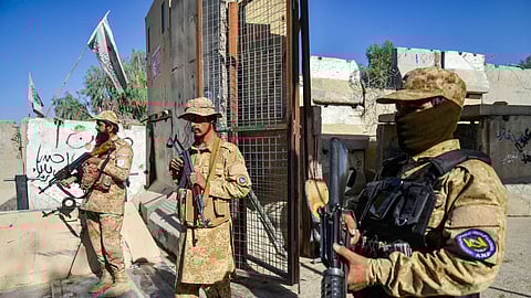 Armed Taliban security personnel keep guard near the closed gate of the zero point border crossing between Afghanistan and Pakistan at Spin Boldak district in Kandahar province