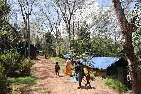 A family walks past the temporary sheds set up for families in the Arippa land struggle. Hundreds of families have been living here in abominable conditions without basic facilities. 