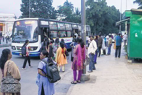 Commuters board a bus a few metres ahead of the bus stop at Balekundri Circle as drivers halt vehicles away from the designated spot.