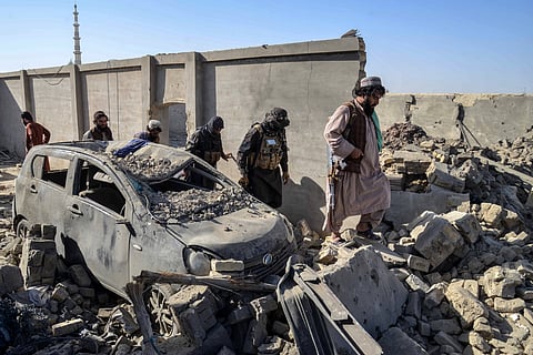 Afghan refugees gather beside trucks loaded with their belongings as they wait their turn to leave for their homeland through a border crossing point which partially opens following Oct.19 ceasefire, on the outskirts of Chaman, a border town on the Pakistan Afghan border, Wednesday, Oct. 29, 2025.