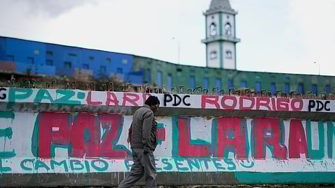 A man walks past a mural promoting presidential candidate Rodrigo Paz days ahead of the runoff election in El Alto, Bolivia, Thursday, Oct. 16, 2025.