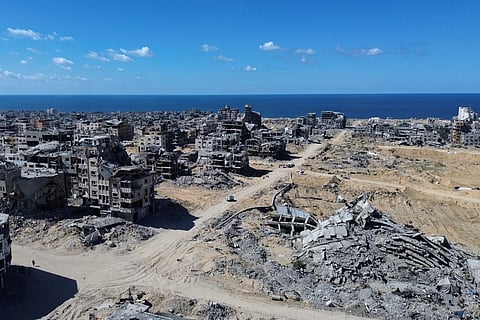 Palestinians carry jerrycans with water they collect from a truck in Gaza City, Thursday, Oct. 16, 2025.