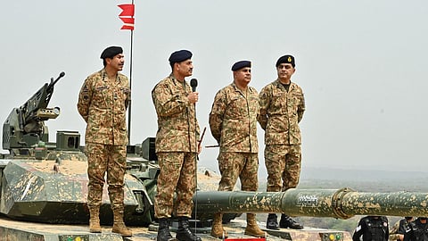 This handout photograph taken on May 1, 2025 and released by the Pakistan's Inter Service Public Relation (ISPR) shows Pakistan's Army Chief General Syed Asim Munir (2L) standS on military tank whicle speaking with army troops.
