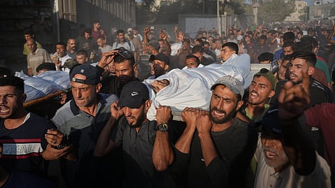 Mourners carry bodies of Palestinians killed by Israeli fire, during their funeral in Deir al-Balah, Gaza Strip, Sunday, Oct. 19, 2025.