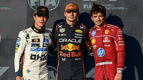 Red Bull Racing's Dutch driver Max Verstappen (C), winner of the pole position, stands alongside McLaren's British driver Lando Norris (L), second place, and Ferrari's Monegasque driver Charles Leclerc (R), third place.