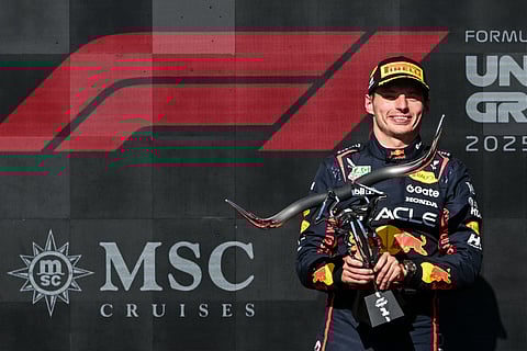 Race winner Red Bull Racing's Dutch driver Max Verstappen holds the trophy on the podium after the United States Formula One Grand Prix at the Circuit of the Americas in Austin, Texas, on October 19, 2025.