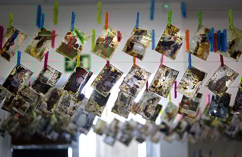 A picture taken in Valencia on October 2, 2025 shows pictures drying on clotheslines after cleaning process as University of Fine Arts' students restore family photographs that have been damaged by mud during the flood.