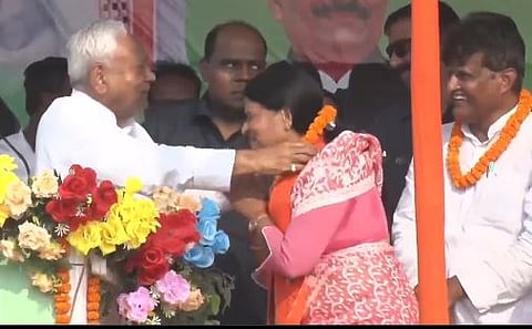Nitish Kumar's close aide and JDU working president Sanjay Kumar Jha hurriedly tried to prevent the CM from creating a scene by catching hold of his hand. Kumar lowers his hand, but suddenly places the garland on the woman's neck. 