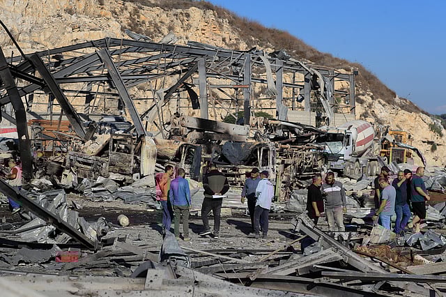 People inspect the site of an Israeli airstrike on a cement plant in the southern Lebanese village of Ansar, Lebanon, Friday, Oct. 17, 2025.