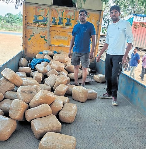 Anti-narcotics officials with the ganja seized on its way to Uttar Pradesh at Simdega on the Ranchi-Rourkela Road in Jharkhand on Wednesday