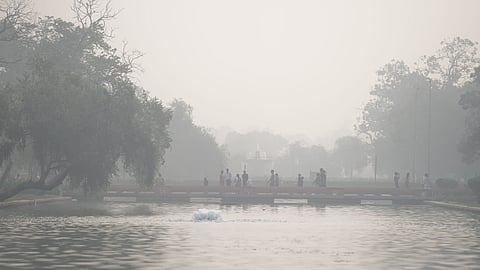 People move along a foundation pathway on a hazy morning as thick smog engulfs the city, at Man Singh Road in New Delhi, Wednesday.