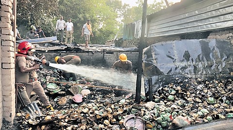 Fire services personnel dousing the blaze at Unit-I vegetable market in Bhubaneswar on Wednesday