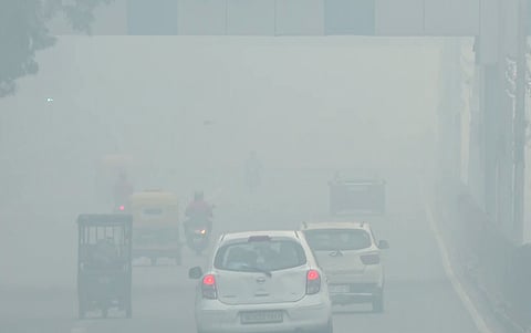 People move along a foundation pathway on a hazy morning as thick smog engulfs the city, at Man Singh Road in New Delhi, Wednesday.