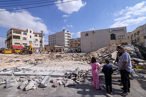 Palestinian children gather to receive food portions from a charity kitchen in the Nuseirat refugee camp, located in the central Gaza Strip, on October 21, 2025, a week after a ceasefire came into effect.