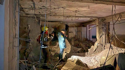 Investigators working in the damaged multi-storey apartment building hit by a Ukrainian drone in Krasnogorsk, just outside Moscow, Russia, on Friday, Oct. 24, 2025.