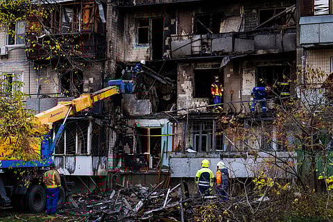 Firefighters work at a destroyed apartment building after a Russian drone attack in Kyiv, Ukraine, Sunday, Oct. 26, 2025. 
