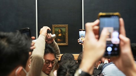 Visitors watch Leonardo da Vinci's painting Mona Lisa in Louvre museum three days after historic jewels were stolen in a daring daylight heist, Wednesday, Oct. 22, 2025 in Paris.