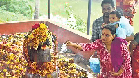 Devotees offer prayers at a snakepit on the occasion of Nagula Chaviti in Vijayawada on Saturday. 