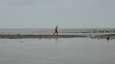 A man walks along the coastline ahead of the forecasted arrival of Hurricane Melissa in Old Harbour, Jamaica, Monday, Oct. 27, 2025.