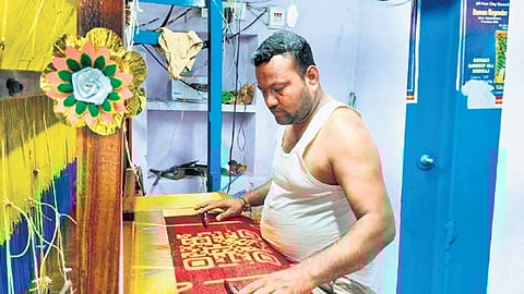 Weaver Nalla Vijay draws a QR code on a silk shawl which, upon scanning, displays PM Narendra Modi’s achievements.