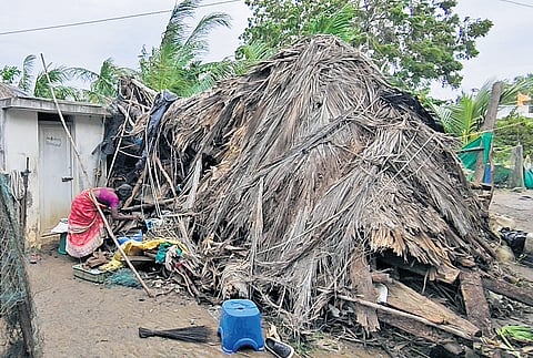 A woman trying to salvage household items at her collapsed hut after returning from the cyclone relief camp at Antarvedi on Wednesday.