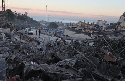 People gather at a site that sold heavy machinery, where a large number of vehicles were destroyed in Israeli airstrikes, in the southern village of Msayleh, Lebanon, Saturday, Oct. 11, 2025.