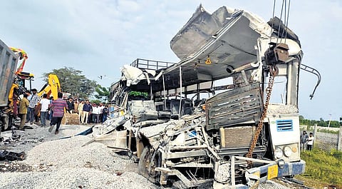 A JCB moves the mangled remains of the bus to clear the road for traffic.