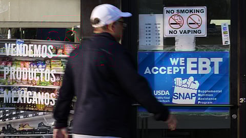 A customer walks into a bakery as a SNAP EBT information sign is displayed at the front door in Chicago, Sunday, Nov. 2, 2025.
