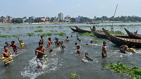 Children cool off in the Buriganga River in Dhaka on June 6, 2023.