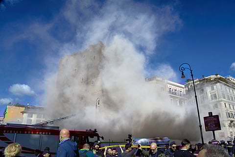 The medieval tower Torre dei Conti near the Roman Forum is engulfed by a cloud of debris from a second collapse after it had partially collapsed during renovation works, in Rome, Italy, Monday, Nov. 3, 2025