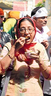 A woman having prasad at the gurdwara
