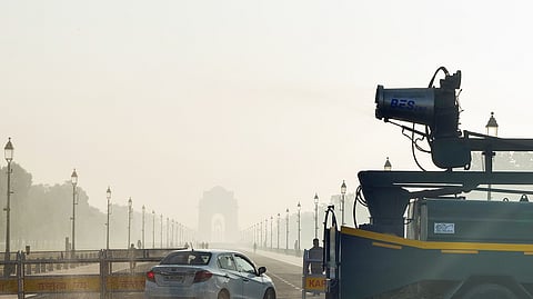 An anti-smog gun sprays fine water droplets to reduce the effects of air pollution, as a thick layer of smog is seen at India Gate in New Delhi on Wednesday.