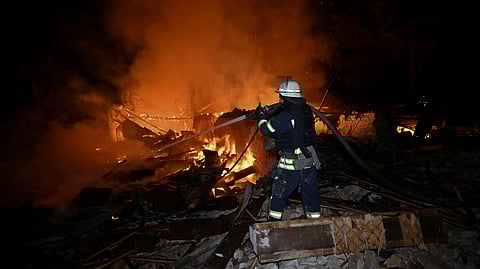 An Ukrainian firefighter extinguishes a fire at the site of a Russian drone strike in the city of Chuguiv, Kharkiv region, early on November 7, 2025.