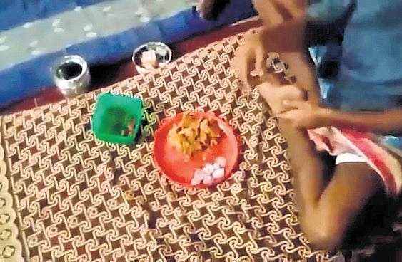 Video grab of an inmate having outside food and liquor bottles at Bengaluru prison